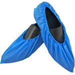 Pair of black shoes covered with blue disposable shoe covers made from waterproof plastic for hygiene and contamination control.